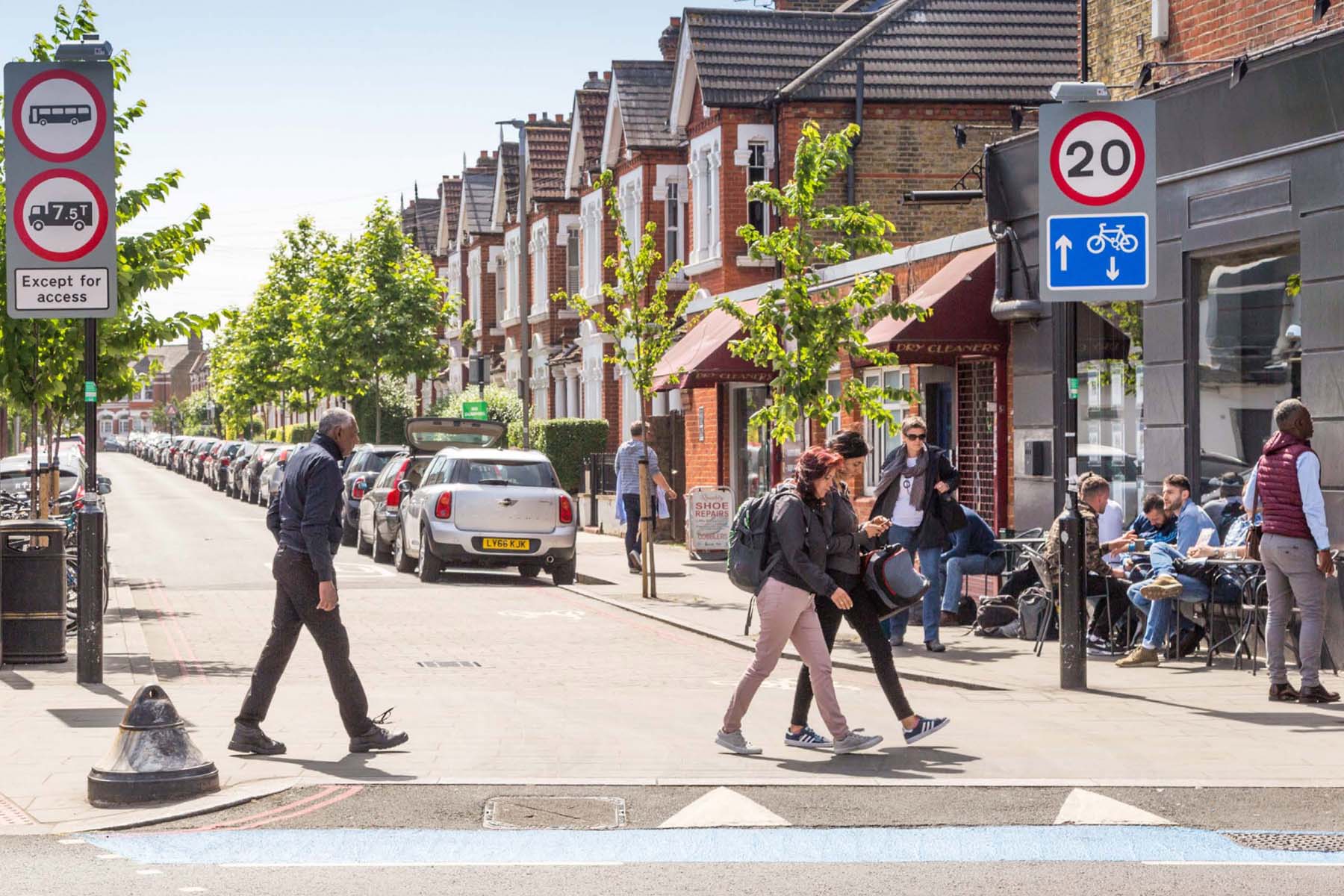 Stadtstraße mit Radweg, Fußgängern, Tempo-20-Zone und Straßencafés