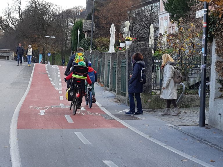 Familie mit Kindern auf Fahrrädern auf einem Radweg in Salzburg unterwegs
