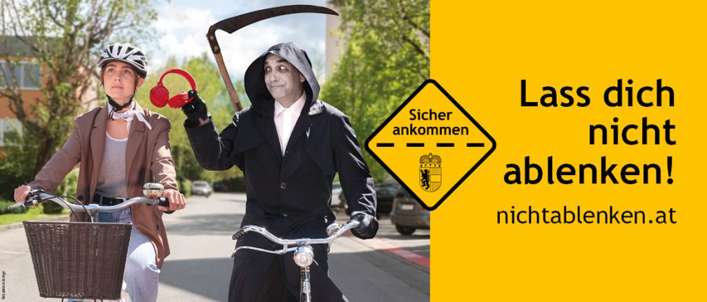 Fahrradfahrerin mit Helm, Sensenmann hält Kopfhörer, Verkehrssicherheit Salzburg