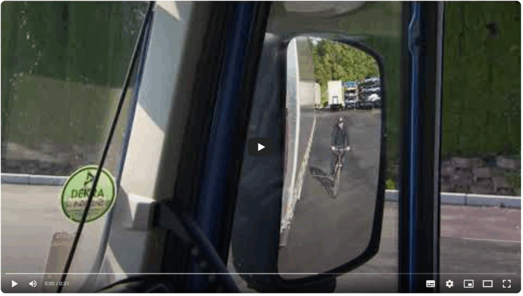 Radfahrer im Rückspiegel eines Lkw sichtbar