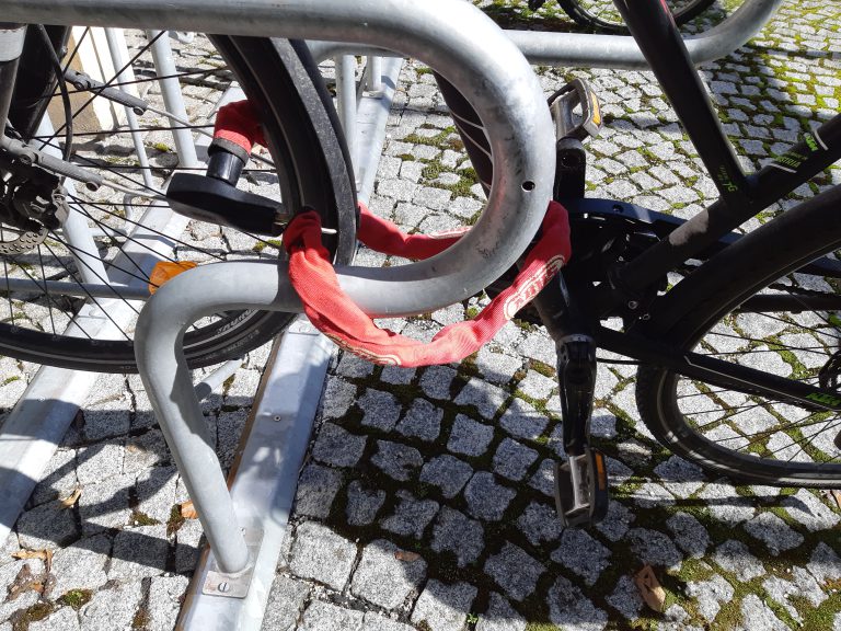 Fahrrad mit rotem Schloss an Radständer